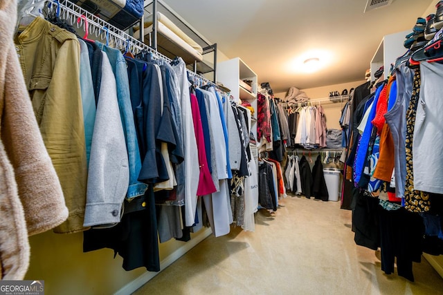 walk in closet featuring light colored carpet