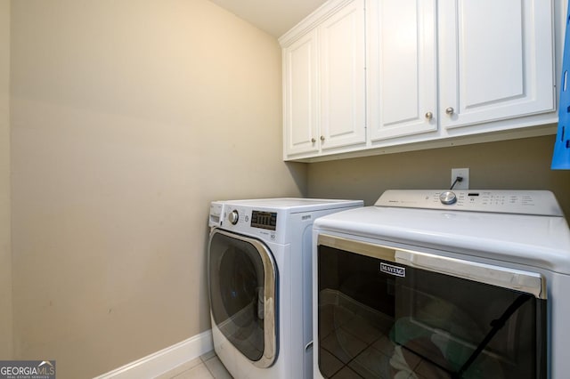 clothes washing area featuring light tile patterned floors, cabinets, and separate washer and dryer