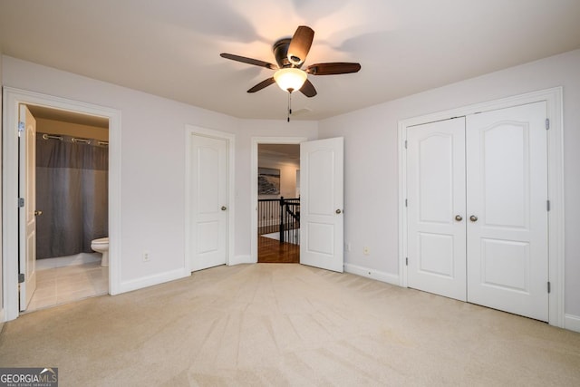 unfurnished bedroom featuring light carpet, connected bathroom, and ceiling fan