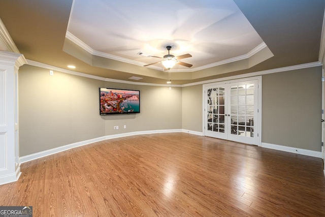 unfurnished room featuring crown molding, wood-type flooring, ceiling fan, french doors, and a tray ceiling