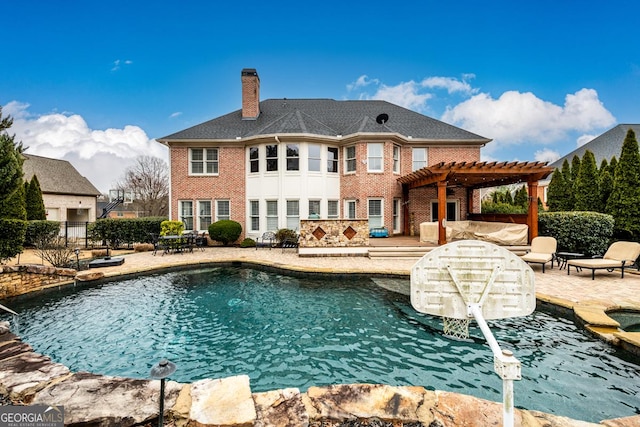 rear view of property with a patio area and a pergola