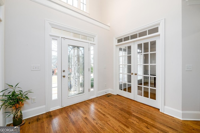 entryway featuring french doors, a healthy amount of sunlight, and wood-type flooring