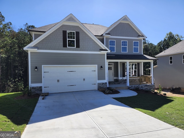 craftsman-style house with a front lawn, a garage, and a porch