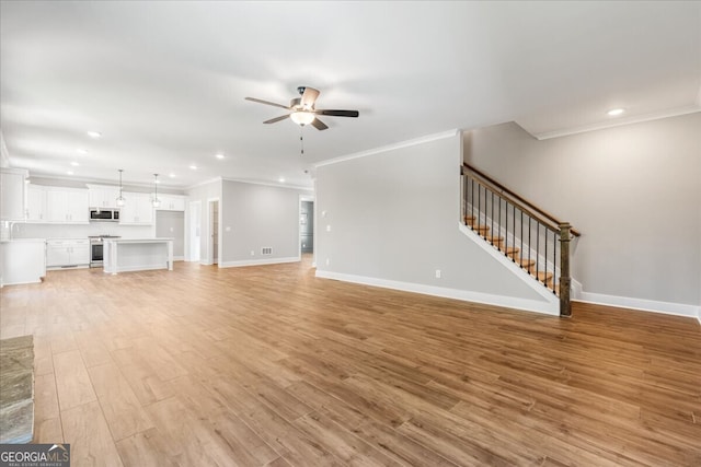 unfurnished living room featuring ceiling fan, ornamental molding, and light wood-type flooring