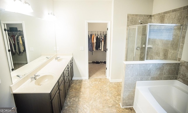 bathroom with vanity and shower with separate bathtub