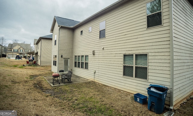 rear view of property featuring a yard and a patio