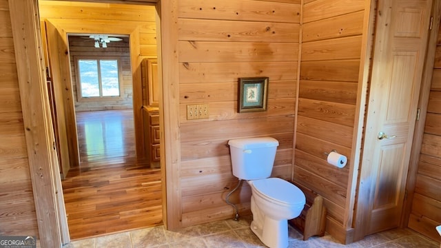 bathroom with toilet and wooden walls