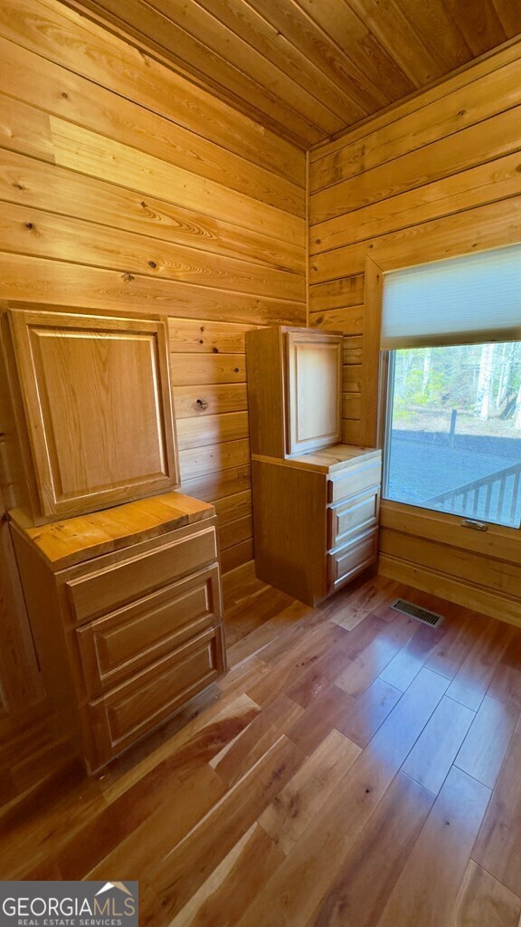 interior space featuring hardwood / wood-style flooring, wooden ceiling, and wood walls