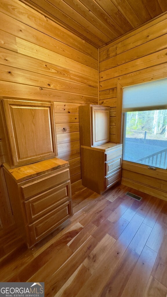 interior space featuring wooden ceiling, wooden walls, wood finished floors, visible vents, and a sauna