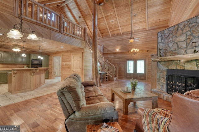 130 Stablegate Dr, Blairsville, GA 30512 - living area with a ceiling fan, a wood ceiling with exposed beams, stairway, wooden walls, and a stone fireplace