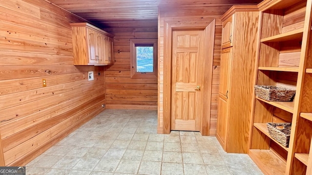 laundry area featuring hookup for a washing machine, wood ceiling, cabinet space, and wooden walls