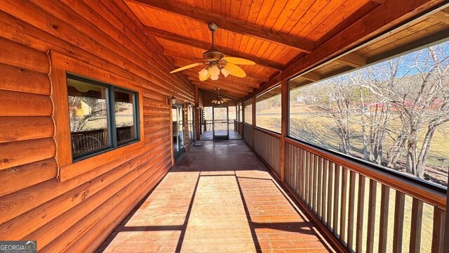 unfurnished sunroom featuring wooden ceiling, ceiling fan, and lofted ceiling with beams