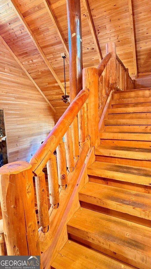 stairs featuring beamed ceiling and wood ceiling