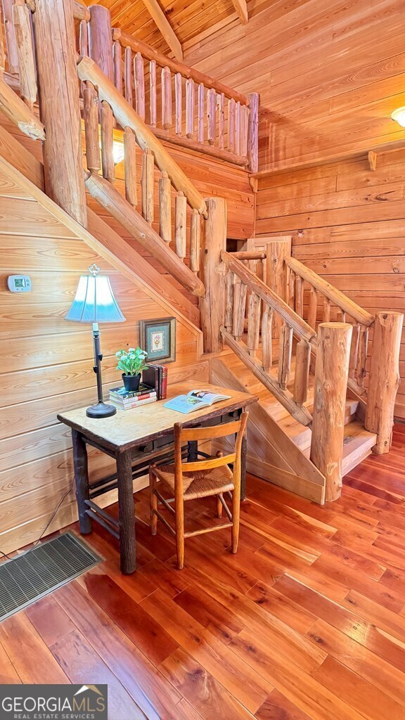 dining area featuring wooden ceiling, wood-type flooring, and wooden walls