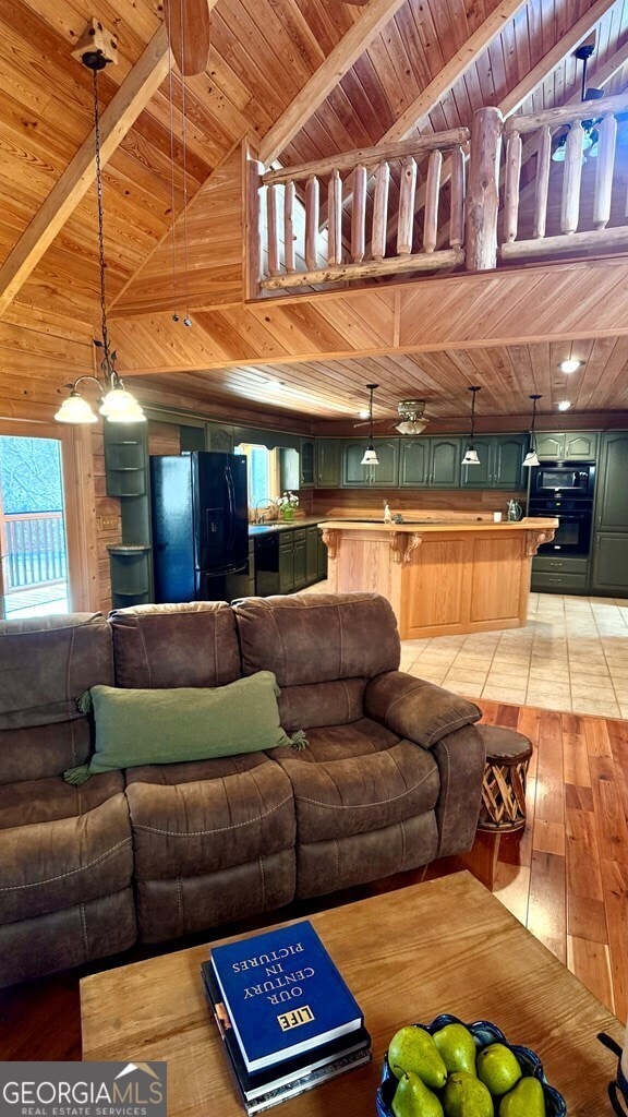 living room featuring light wood-type flooring, wood ceiling, wooden walls, and beamed ceiling