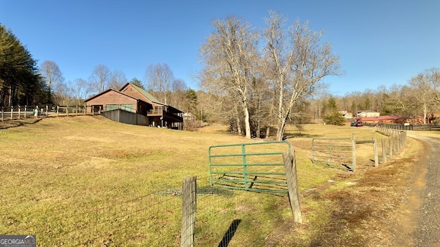 view of yard featuring a gate, fence, and a rural view