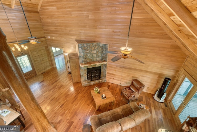 130 Stablegate Dr, Blairsville, GA 30512 - living room featuring a ceiling fan, high vaulted ceiling, wooden walls, a stone fireplace, and hardwood / wood-style flooring