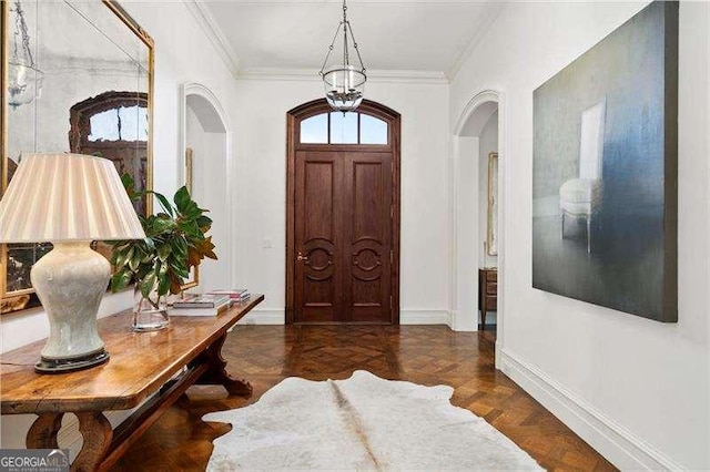 entrance foyer with ornamental molding and dark parquet floors