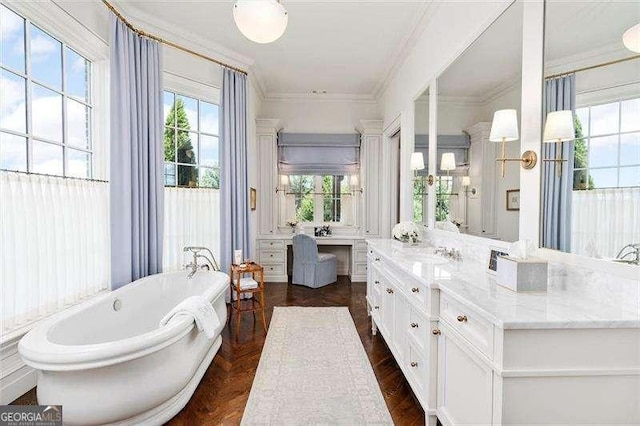 bathroom with crown molding, a tub to relax in, and vanity