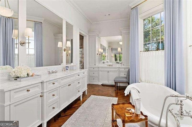 bathroom with ornamental molding, a tub to relax in, vanity, and parquet floors