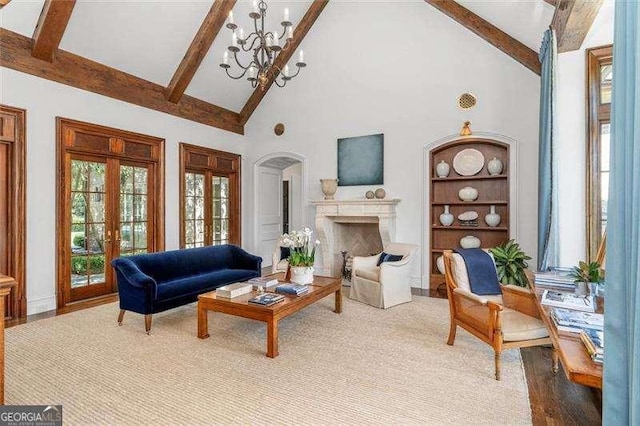 living room featuring beamed ceiling, french doors, built in features, a chandelier, and high vaulted ceiling