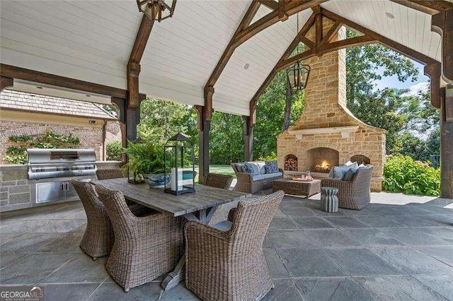 view of patio with area for grilling and an outdoor stone fireplace