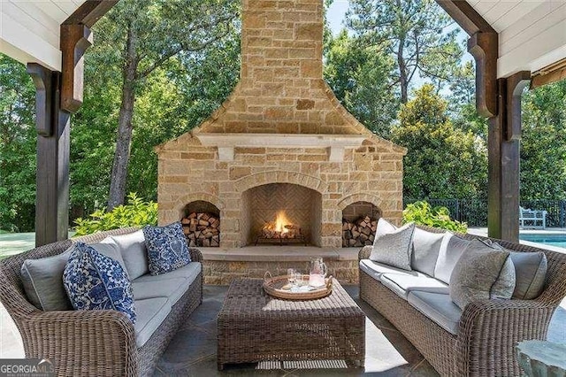 view of patio with an outdoor living space with a fireplace