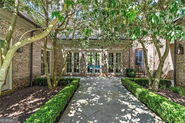 view of exterior entry with a patio area