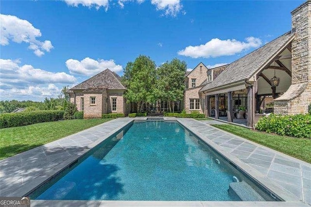 view of swimming pool featuring a yard and an outdoor structure