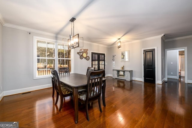 dining space featuring ornamental molding, dark hardwood / wood-style floors, and a chandelier