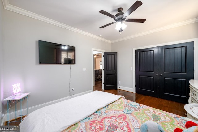 bedroom with crown molding, dark wood-type flooring, ceiling fan, and a closet