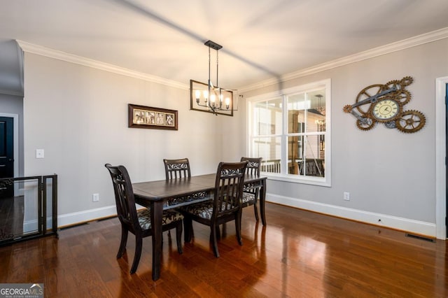 dining room featuring ornamental molding, dark hardwood / wood-style floors, and a chandelier