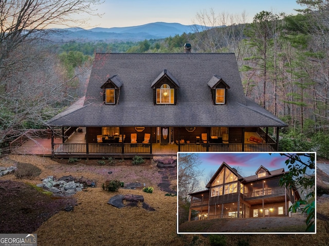 exterior space with a balcony, a mountain view, and a wooded view