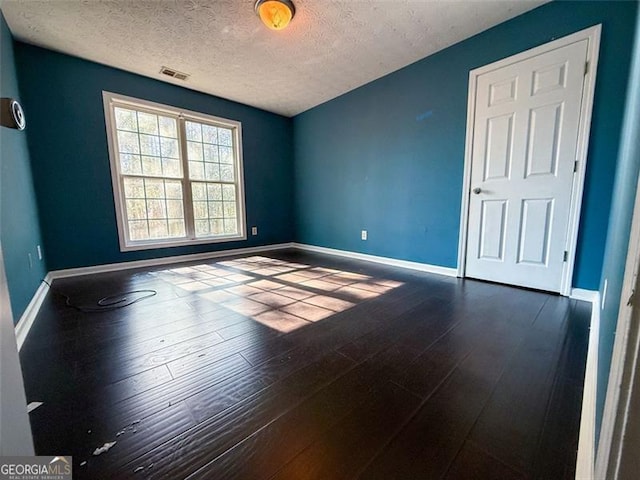 unfurnished room featuring wood-type flooring and a textured ceiling