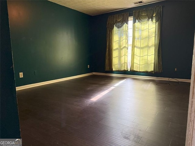 spare room with a textured ceiling and wood-type flooring