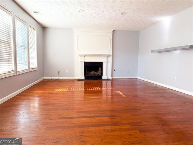 unfurnished living room featuring a textured ceiling and hardwood / wood-style flooring