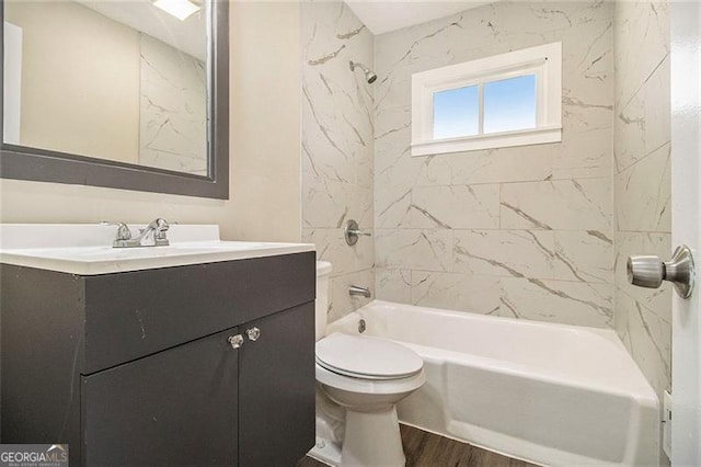 full bathroom featuring wood-type flooring, toilet, vanity, and tiled shower / bath