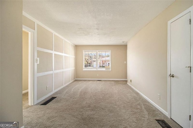 carpeted spare room featuring a textured ceiling