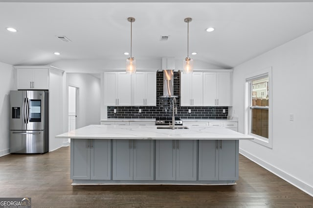 kitchen featuring stainless steel refrigerator with ice dispenser, lofted ceiling, white cabinets, and wall chimney exhaust hood