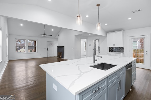 kitchen with dishwasher, an island with sink, lofted ceiling, sink, and hanging light fixtures