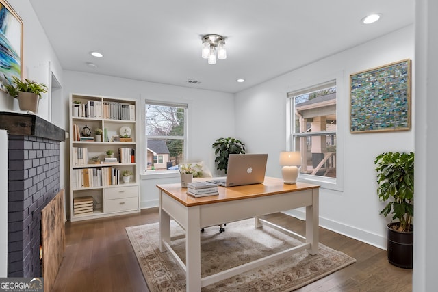 office with plenty of natural light, dark wood-type flooring, and a fireplace