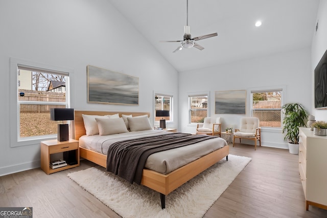 bedroom with multiple windows, high vaulted ceiling, ceiling fan, and light wood-type flooring