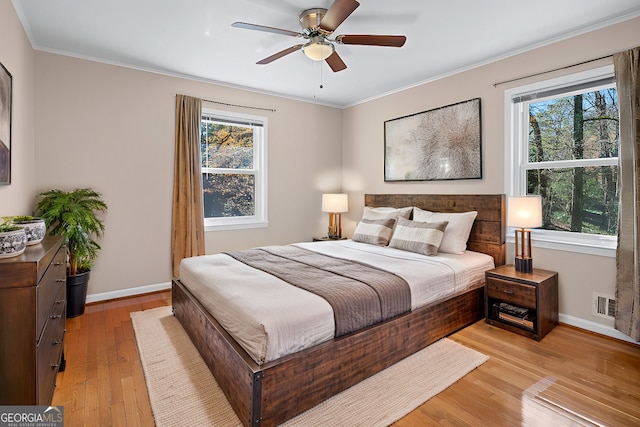 bedroom with crown molding, ceiling fan, and light wood-type flooring