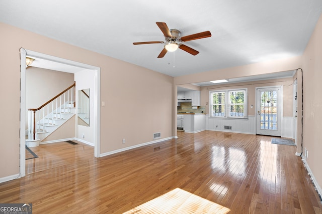 unfurnished living room featuring ceiling fan and light wood-type flooring