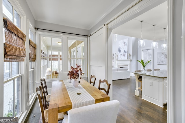 dining area with dark hardwood / wood-style flooring, crown molding, and a barn door