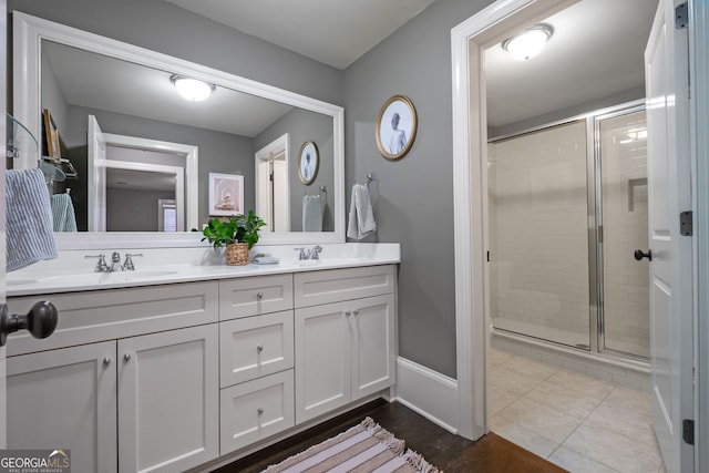 bathroom with a shower with door, vanity, and tile patterned flooring