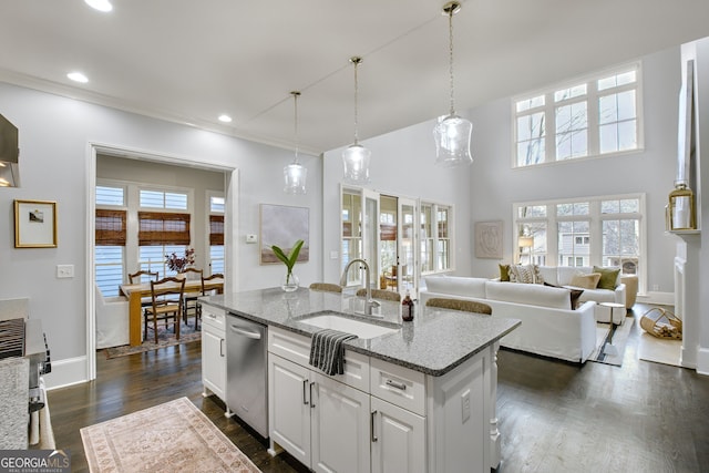 kitchen featuring sink, light stone countertops, an island with sink, white cabinets, and stainless steel dishwasher