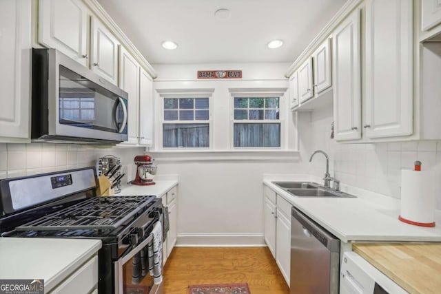 785 Ponce De Leon Pl NE Unit 8, Atlanta, GA 30306 - kitchen with stainless steel appliances, light countertops, decorative backsplash, white cabinetry, and recessed lighting