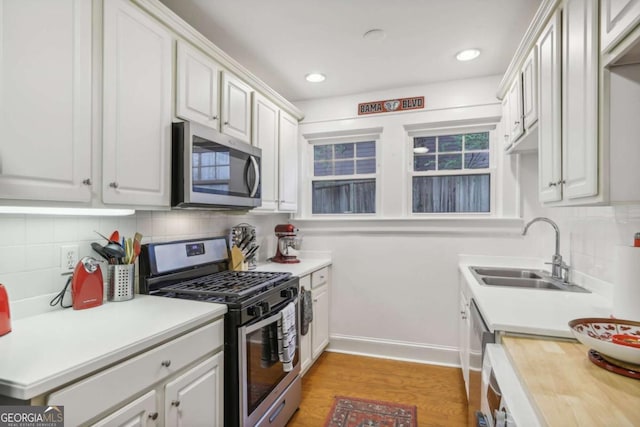 785 Ponce De Leon Pl NE Unit 8, Atlanta, GA 30306 - kitchen with stainless steel appliances, decorative backsplash, light wood-style flooring, white cabinets, and recessed lighting