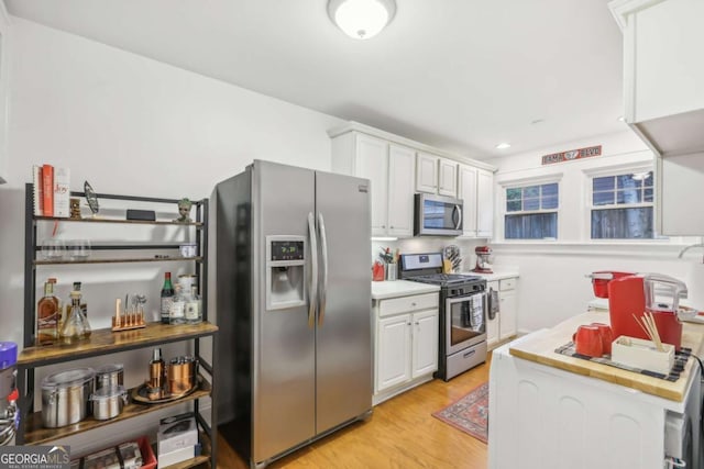 785 Ponce De Leon Pl NE Unit 8, Atlanta, GA 30306 - kitchen featuring stainless steel appliances, light countertops, white cabinetry, and light wood-type flooring